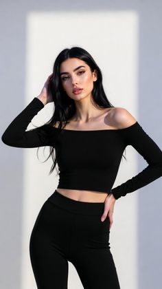 Woman with long black hair wearing a black off-shoulder crop top