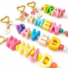 Colorful letter bead keychains with heart-shaped clasps and various charms