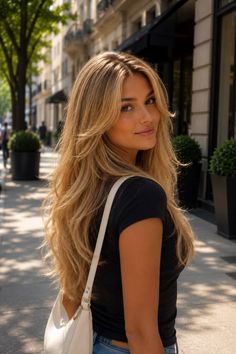 Woman with long blonde hair and a black t-shirt on a sunny street
