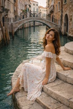 Woman in a floral dress sitting on stone steps by a canal in Venice