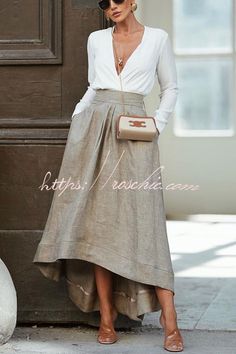 Woman in a white blouse and long skirt with sunglasses and jewelry outdoors