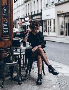 Woman with a bun hairstyle sitting at a street cafe table