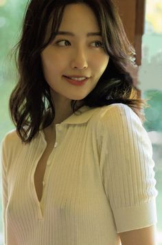 Woman with long hair in a white shirt with visible cleavage and exposed skin