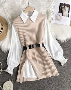 Knitted vest over a white collared shirt with a black belt