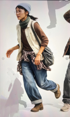 Woman in a blue beanie and plaid shirt over a sweater, wearing jeans and boots