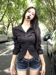 Woman in a black shirt and denim shorts on a street