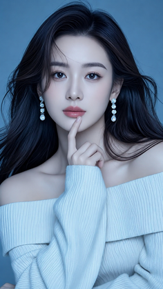 Woman with long dark hair wearing an off-shoulder top and pearl earrings