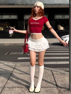 Woman with red hair in a crop top and mini skirt on a city street