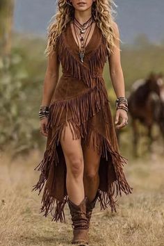 Woman in a brown fringe dress and cowboy boots walking outdoors