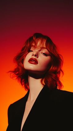 Woman with red hair and red lipstick against a red and orange gradient background