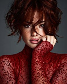Woman with red hair and freckles wearing a red sequined top