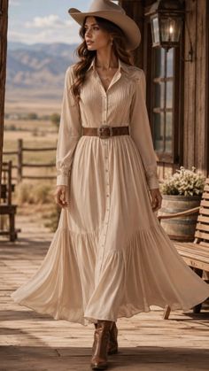 Woman in a cowboy hat and long dress on a wooden porch with a countryside background