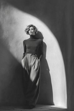 Woman in a turtleneck and wide leg pants with dramatic lighting