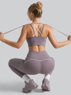 Woman in athletic wear squatting with her back to the camera
