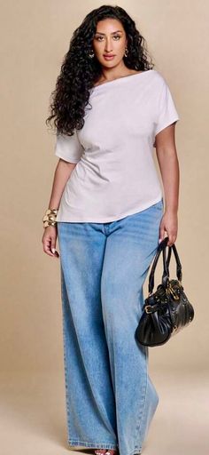 Woman with long curly hair wearing a white t-shirt and wide leg jeans