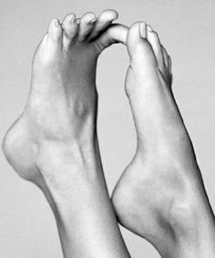 Two feet with toes intertwined in a black and white close-up