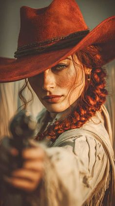 Cowgirl with red hair and freckles wearing a red hat and holding a gun