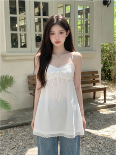 Woman with long dark hair wearing a white top and jeans outdoors