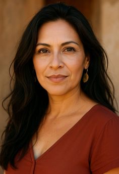 Woman with long dark hair and brown eyes wearing a red top