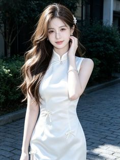 Woman with long brown hair wearing a white cheongsam dress outdoors