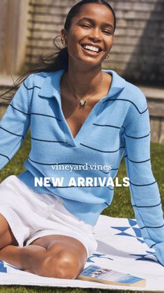 Smiling woman in a blue striped sweater and white shorts sitting on a blanket outdoors