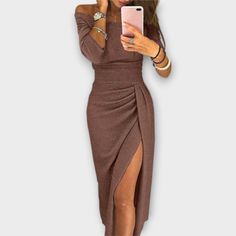 Woman in a brown off-shoulder dress with a high slit taking a mirror selfie