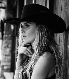 Woman in a cowboy hat with long wavy hair in black and white