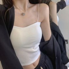 Person in a white camisole and black jacket with exposed midriff