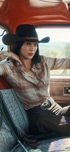 Woman in a cowboy hat and plaid shirt inside a car