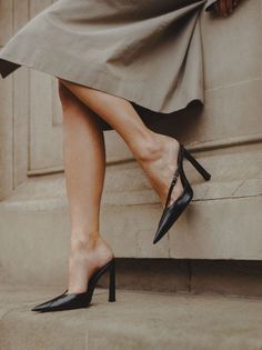 Woman in a beige dress and black high heels with exposed skin