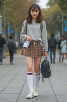 Young woman in a plaid skirt and knee-high socks walking on a street