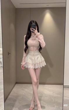 Woman in a lace top and mini skirt taking a mirror selfie