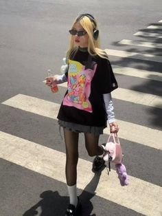 Blonde woman in sunglasses and headphones walking on a street crossing