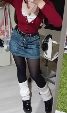 Person in a red top, denim skirt, black tights, and white leg warmers