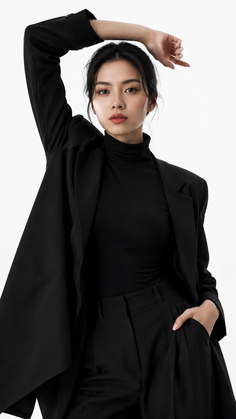 Woman in a black suit and turtleneck posing in a studio