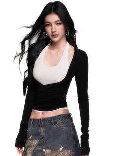 Woman with long black hair wearing a cropped top and denim skirt