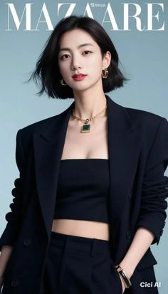 Woman with short black hair wearing a blazer and crop top with jewelry