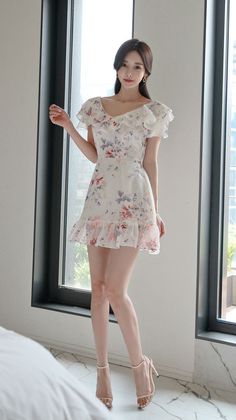 Woman in a white floral ruffle dress and high heels indoors
