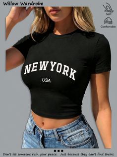 Woman in a black crop top and denim shorts with exposed midriff