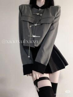 Person in a cropped jacket, pleated skirt, and thigh high socks with a garter belt