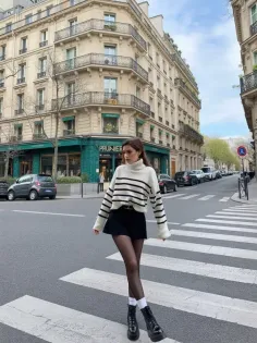 Woman in a striped sweater and black skirt on a city street
