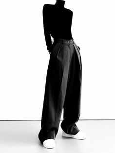 Person in a black turtleneck and wide leg pants with white sneakers