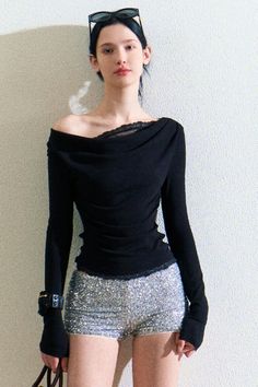 Woman in a black off-shoulder top and silver sequin shorts