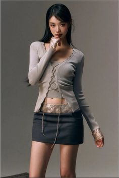 Woman in a mini skirt and cropped top posing in a studio