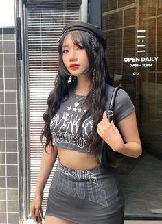 Woman with long dark hair wearing a crop top and mini skirt outdoors