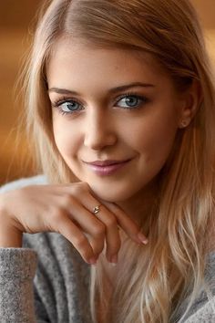 Close-up portrait of a young woman with blonde hair and blue eyes