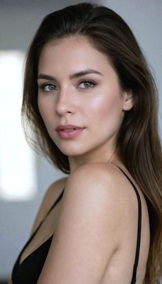 Woman with long brown hair and green eyes wearing a black top