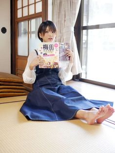 Woman with short hair sitting on a tatami mat, holding a magazine