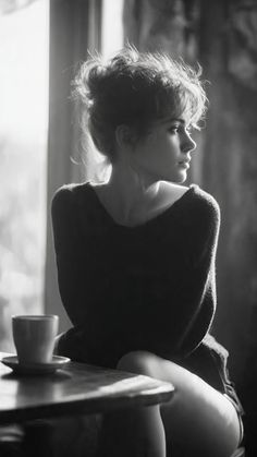 Woman with a messy bun looking away, bathed in soft backlight indoors