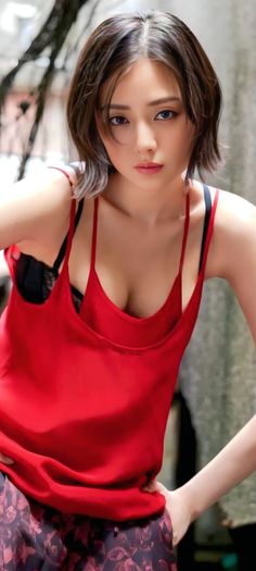 Woman with short hair wearing a red top and black bra, upper body portrait